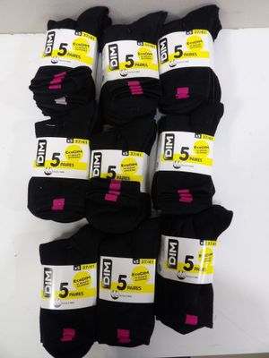 five pairs of black socks are stacked on a white surface