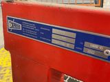 a close up of a red machine with a blue label on it