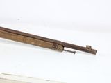 an old gun that is laying on a white surface