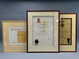three framed certificates of various sizes and shapes are displayed in front of a blue background
