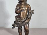 statue en bronze représentant un garçon tenant un oiseau, posée sur un socle en marbre