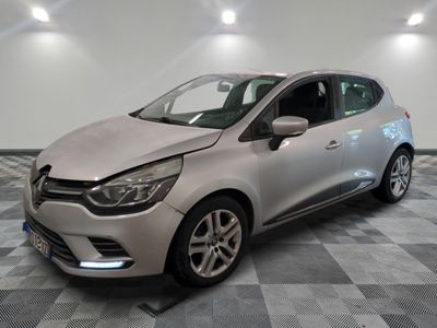 une voiture argentée est garée dans une pièce au sol en damier