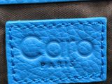 a close up of a blue purse with a tag on it