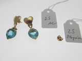 deux paires de boucles d'oreilles et une étiquette de prix posées sur une table