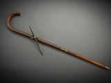 an old cane with a wooden handle sitting on top of a table