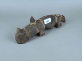 une petite figurine en bois représentant un rhinocéros, avec une étiquette accrochée à son cou