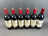 six bottles of red wine lined up in a row