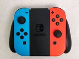 two nintendo switch controllers sitting side by side on a white surface