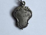 a small silver heart charm with the word love written on it