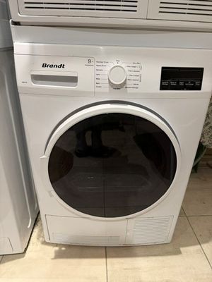 une machine à laver et un sèche-linge posés l'un à côté de l'autre sur le sol
