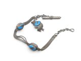 an image of a silver bracelet with blue beads and a bird charm