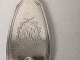 a silver spoon with a design on it sitting on a table