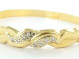 gros plan d'un bracelet en or avec des diamants sur fond blanc
