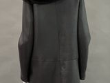 a mannequin wearing a black coat with a fur collar