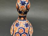 an orange and blue vase sitting on top of a black table