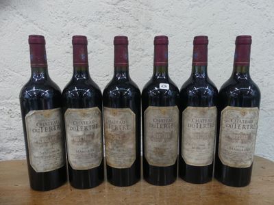 six bouteilles de vin sont alignées sur une table en bois
