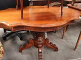 a wooden table with chairs around it in a room