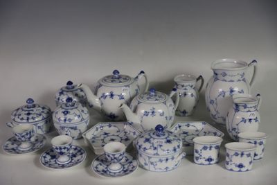 Plusieurs pièces de porcelaine bleue et blanche sont disposées sur une surface blanche