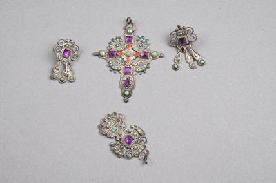 trois bijoux en argent et en pourpre posés sur un fond blanc