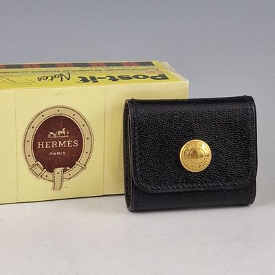 un portefeuille en cuir noir orné d'un bouton doré