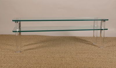 une table basse en verre surmontée d'une étagère en verre