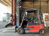 a red fork truck parked inside of a warehouse