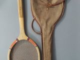 a tennis racket and a bag hanging on the wall