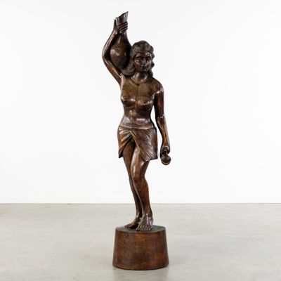 une statue en bronze représentant un homme tenant un oiseau dans la main