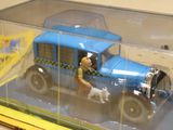 a blue toy truck with a man and a dog inside of it