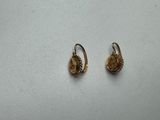 a pair of gold earrings with a flower design on them