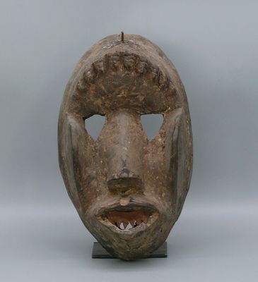 une image d'un masque en bois sur un support
