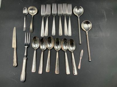 un grand nombre de cuillères et de fourchettes disposées sur une table