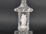 a clear glass bottle with a statue on top of it