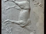 a stone plaque with a horse and a bird on it