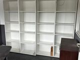 a desk with a chair and a bookcase in the corner