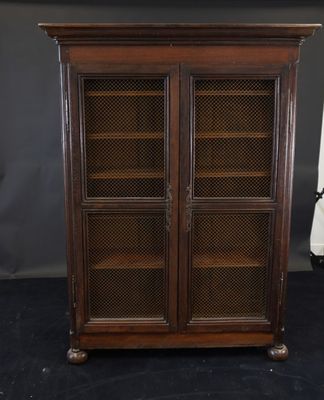 an antique wooden cabinet with glass doors and shelves