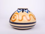 a yellow and blue vase sitting on a white surface