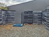 de nombreuses piles de palettes en plastique empilées les unes sur les autres