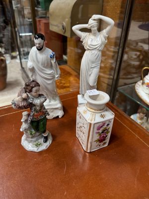 two figurines sitting on a table in front of a glass case