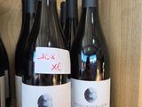 several bottles of wine sit on a shelf in a wine shop
