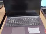 deux ordinateurs portables posés sur une table en bois, avec un mur rouge en arrière-plan