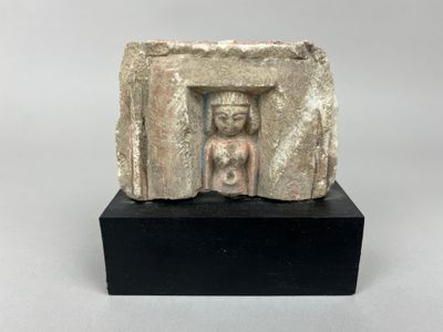 une ancienne statue en pierre représentant une femme dans une embrasure de porte