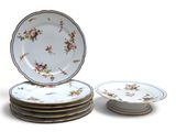 quatre assiettes empilées les unes sur les autres, ornées de fleurs
