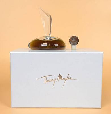 a bottle of perfume sitting on top of a white box