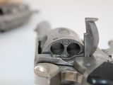 a close up of a gun on a white surface