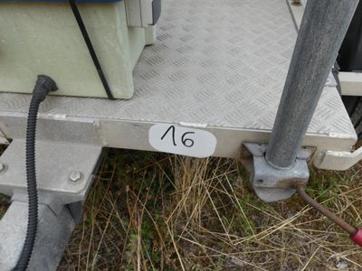 a metal trailer with a hose attached to it