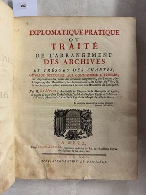 un livre ouvert posé sur une table, à côté d'une feuille de papier