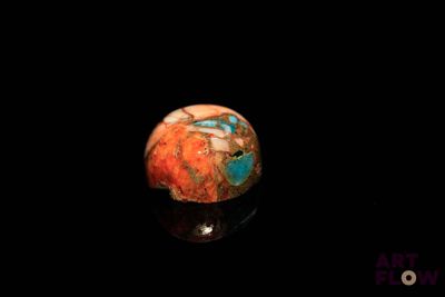 un gros plan d'une balle rouge et bleue posée sur une surface noire
