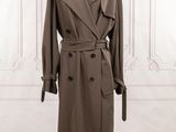 trench coat on a mannequin stand in front of a white wall