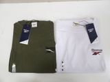 two reebok t - shirts on a table with a price tag